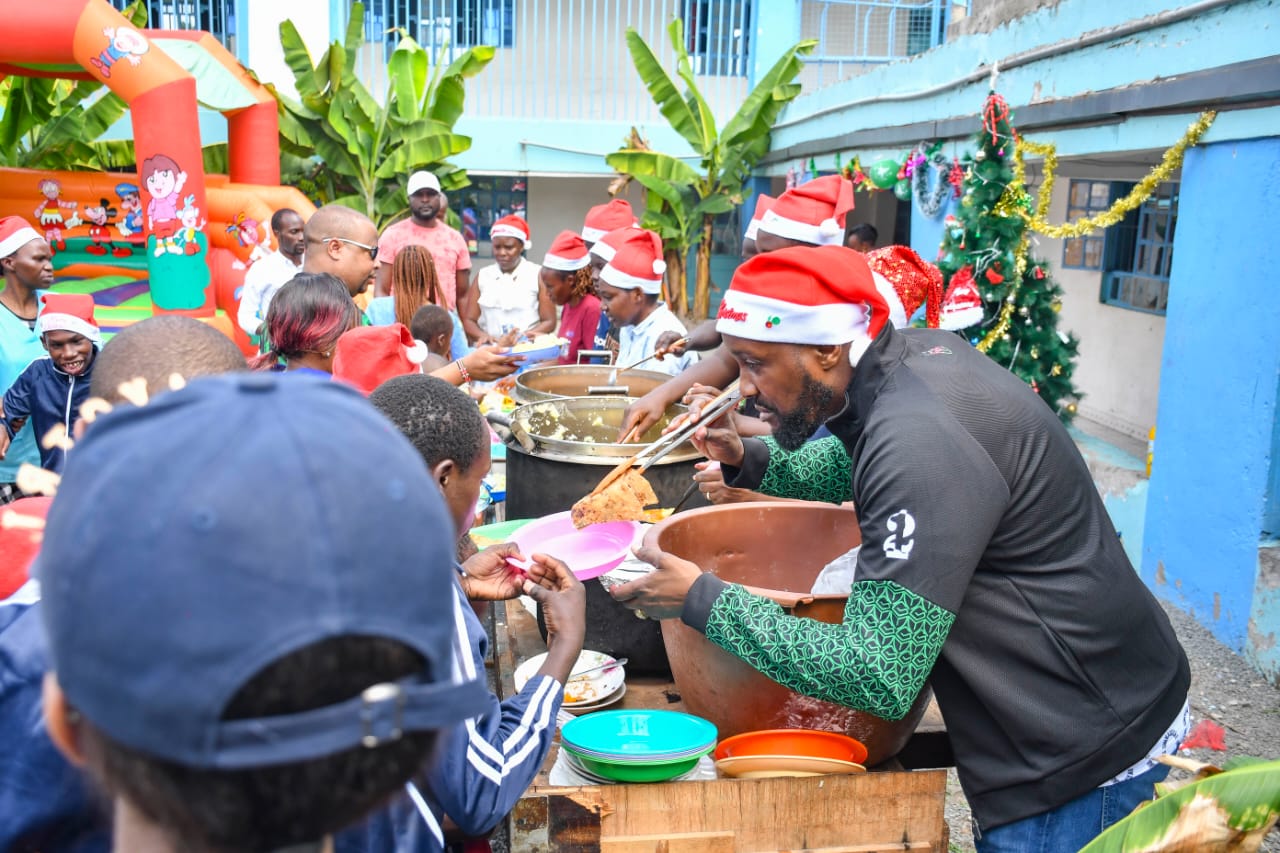 Sportpesa CEO Ronald Karauri serves lunch to children at Compassionate Hands for the Disabled in Ruai on Christmas day. Photo: Courtesy